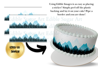 Edible cake border with mountain design and text on a white background